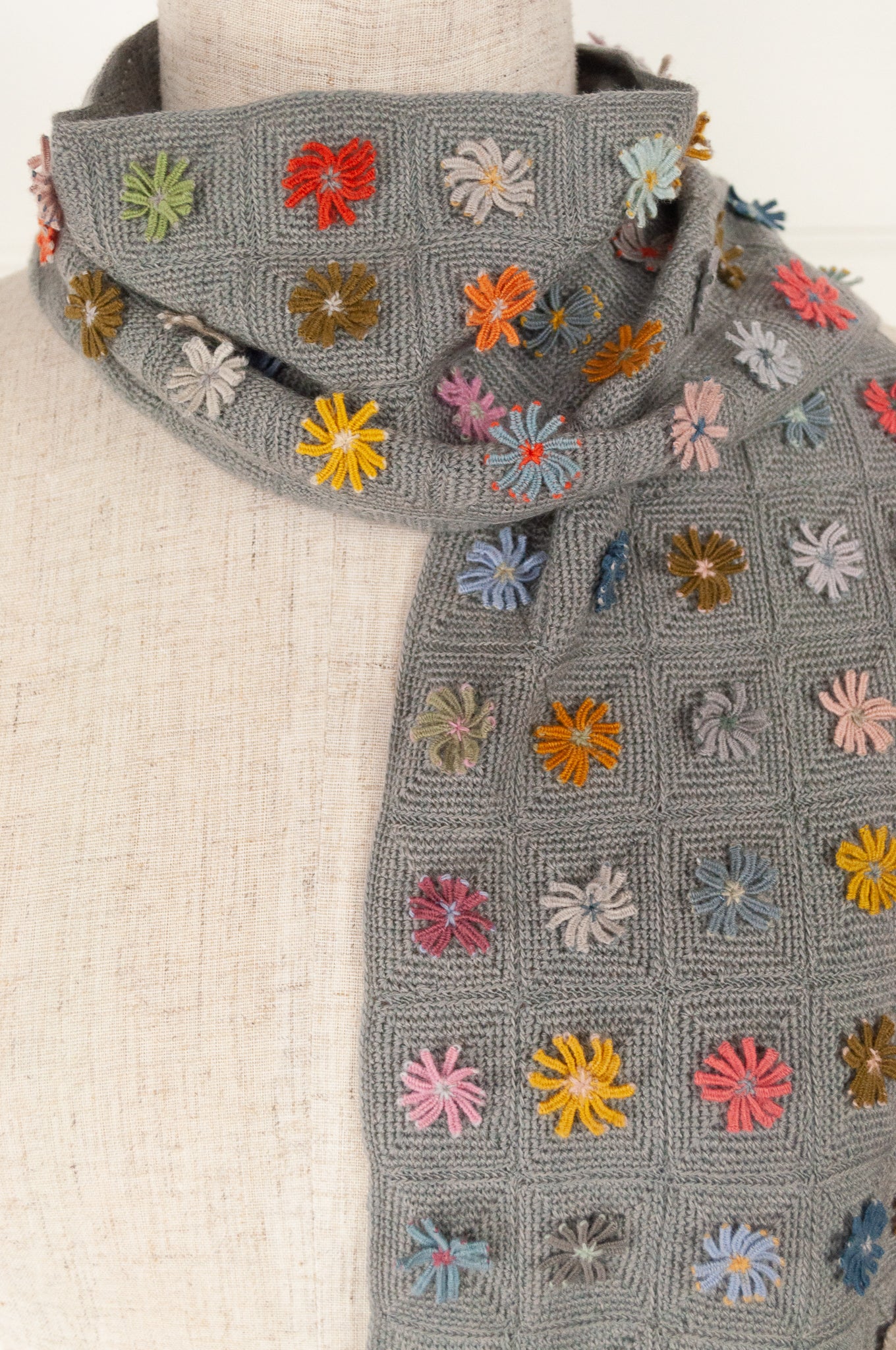 Sophie Digard medium size crochet scarf Ernestine multi colour flowers on a soft sage grey green checkboard base.