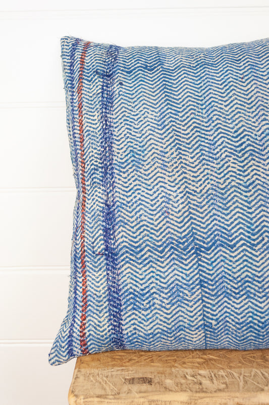Vintage kantha quilt cushion, overdyed with blue and white blockprint chevron stripe pattern with red highlights.