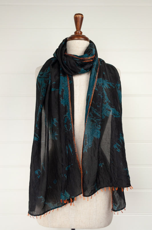 Neeru Kumar fine silk shibori dyed scarf, black with teal green patterning, edge stitched and tassels in neon orange.