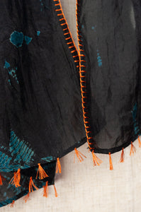 Neeru Kumar fine silk shibori dyed scarf, black with teal green patterning, edge stitched and tassels in neon orange.