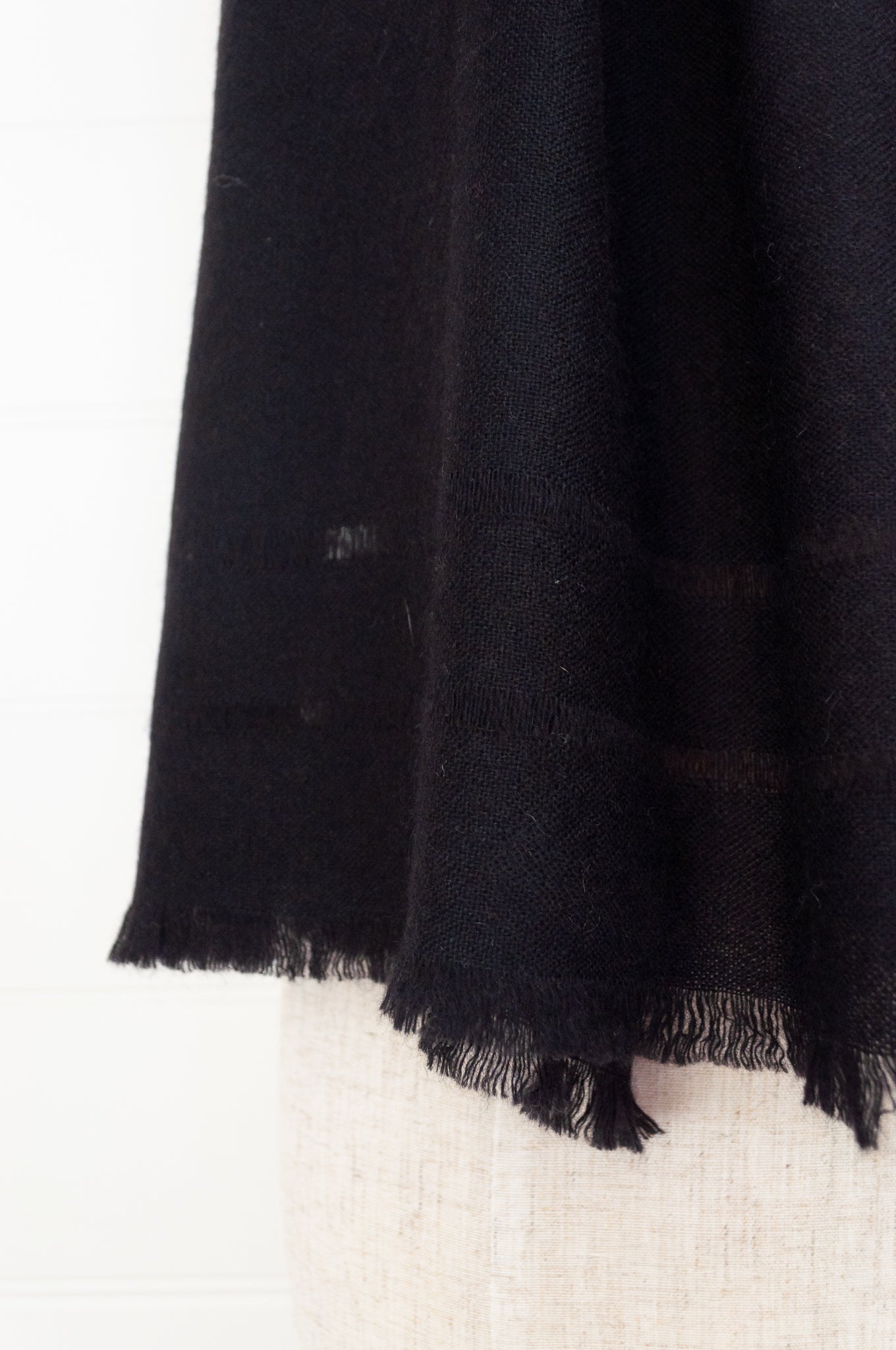 Juniper Hearth woven cashmere scarf featuring fagoting detail and fringed at ends, in black.