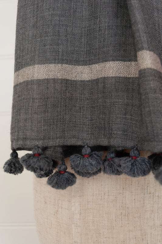 Juniper Hearth woven merino wool scarf, lightweight and very soft, melange dye from charcoal to cherry red, with handmade pompoms.