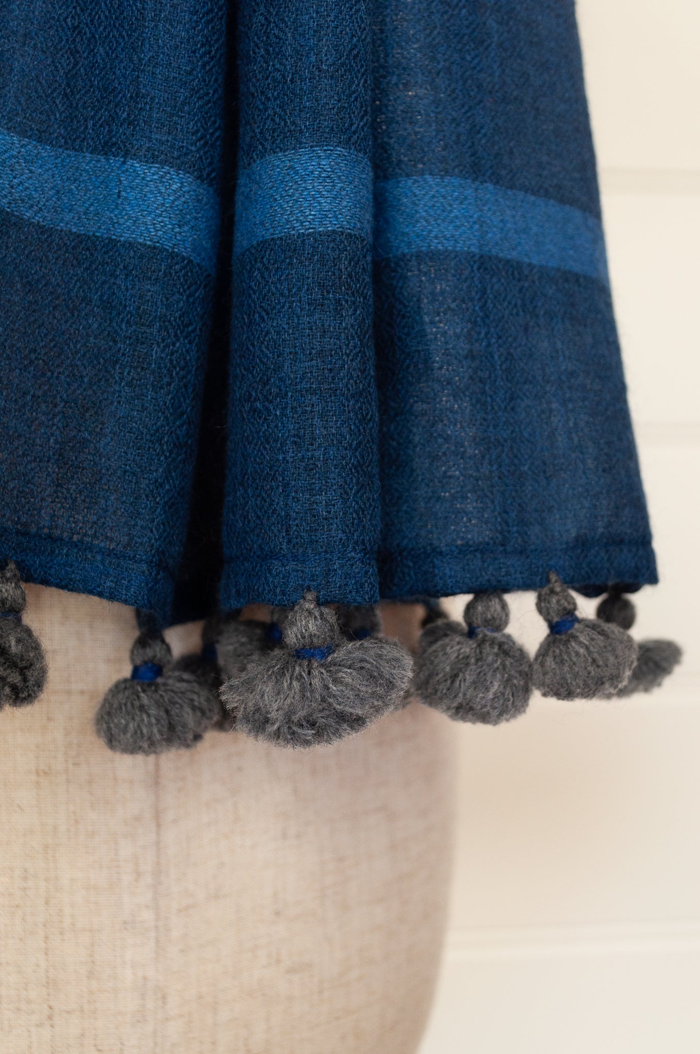 Juniper Hearth woven merino wool scarf, lightweight and very soft, melange dye from charcoal to sapphire blue, with handmade pompoms.