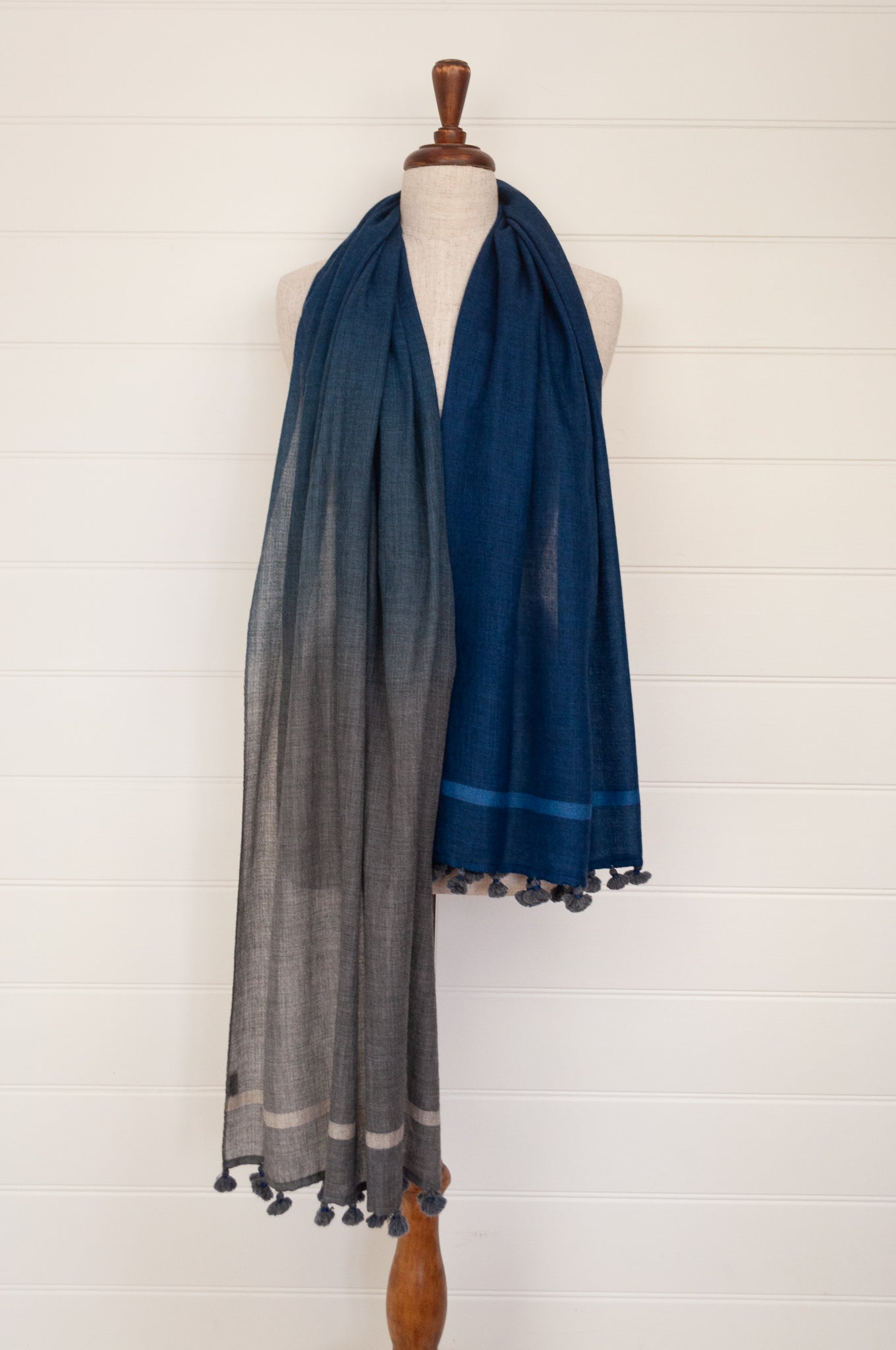 Juniper Hearth woven merino wool scarf, lightweight and very soft, melange dye from charcoal to sapphire blue, with handmade pompoms.