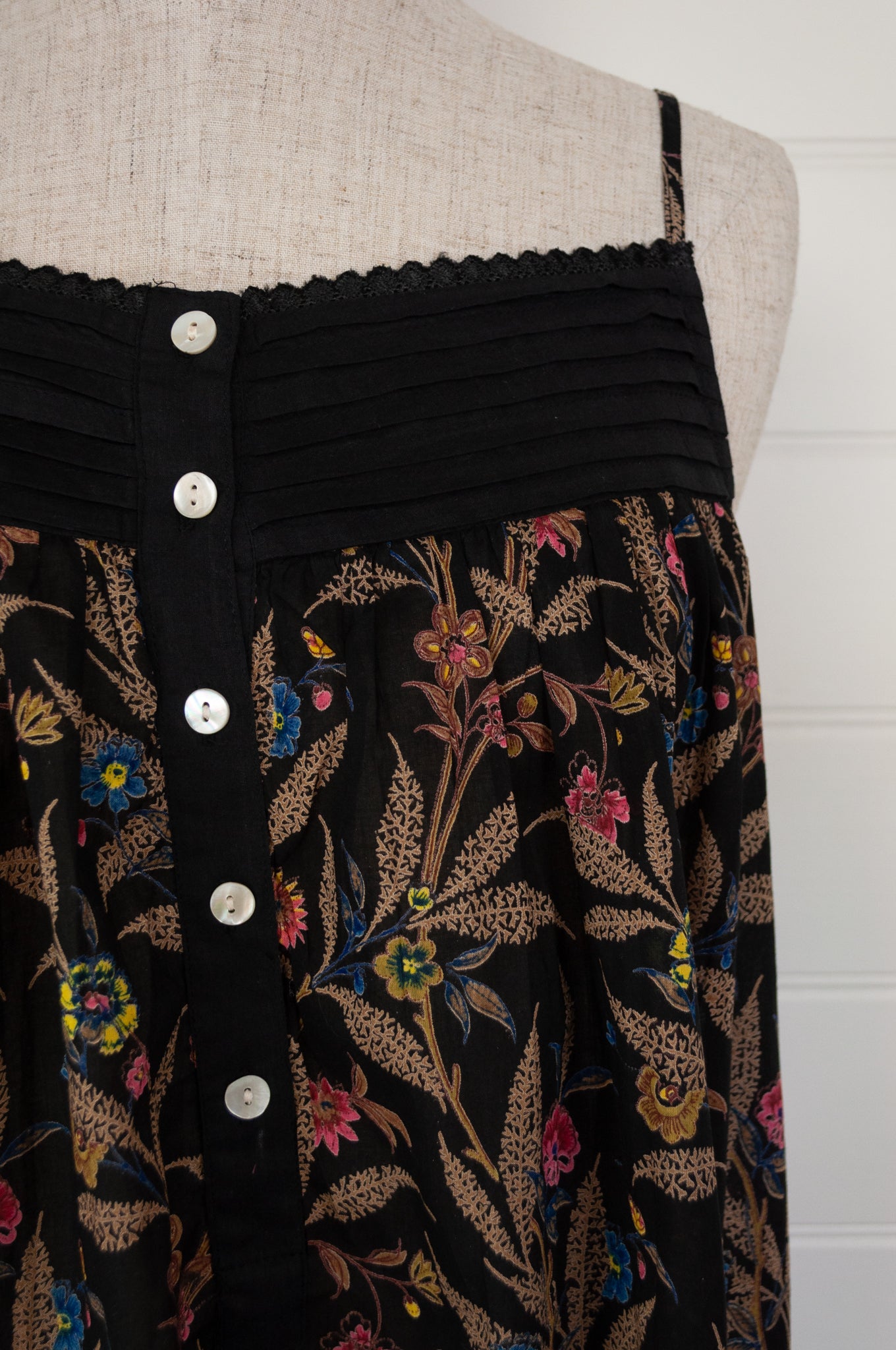 Ethically made pure cotton voile summer nightdress with adjustable straps and pintucked yoke, this nightie is in a wildflower print on black with broderie edging (bodice close up).