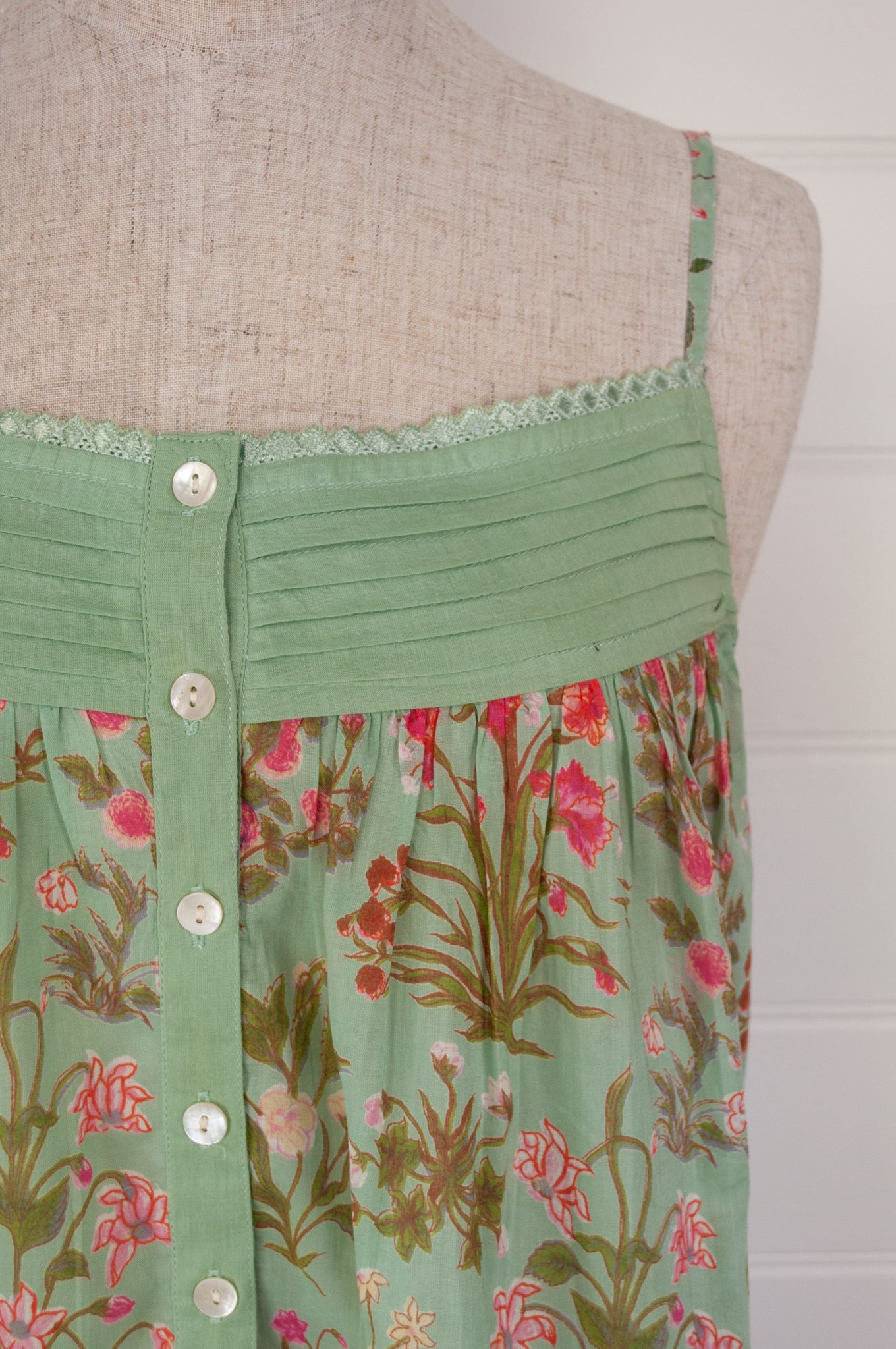 Ethically made pure cotton voile summer nightdress with adjustable straps and pintucked yoke, this nightie is in a mint green floral print with broderie edging (close up front bodice).