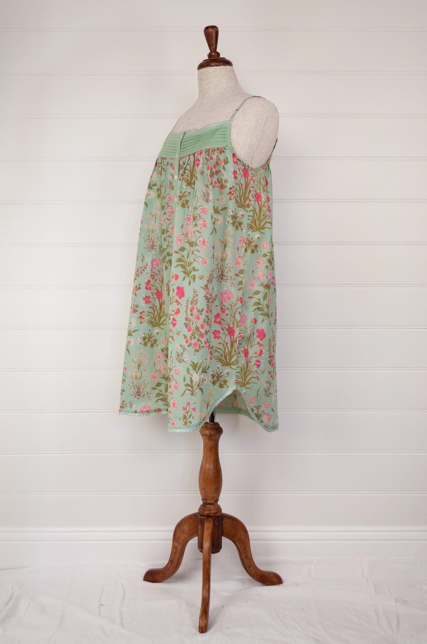 Ethically made pure cotton voile summer nightdress with adjustable straps and pintucked yoke, this nightie is in a mint green floral print with broderie edging (side view).