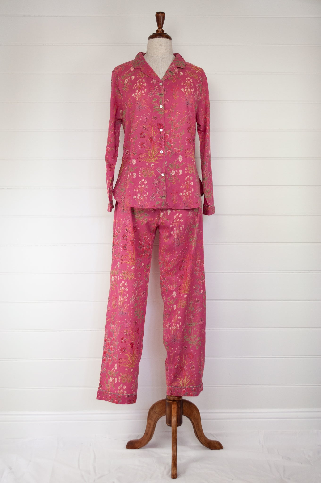 Ethically made cotton voile pyjamas with garden flowers of pink, red and vanilla on a deep raspberry pink red background.
