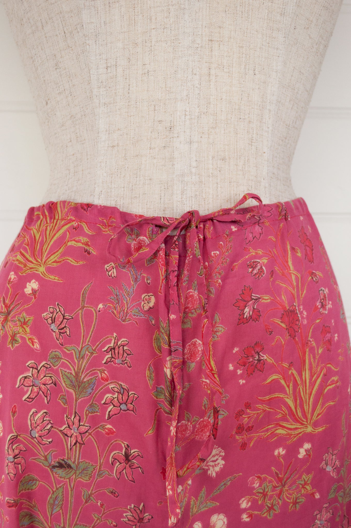 Ethically made cotton voile pyjamas with garden flowers of pink, red and vanilla on a deep raspberry pink red background.
