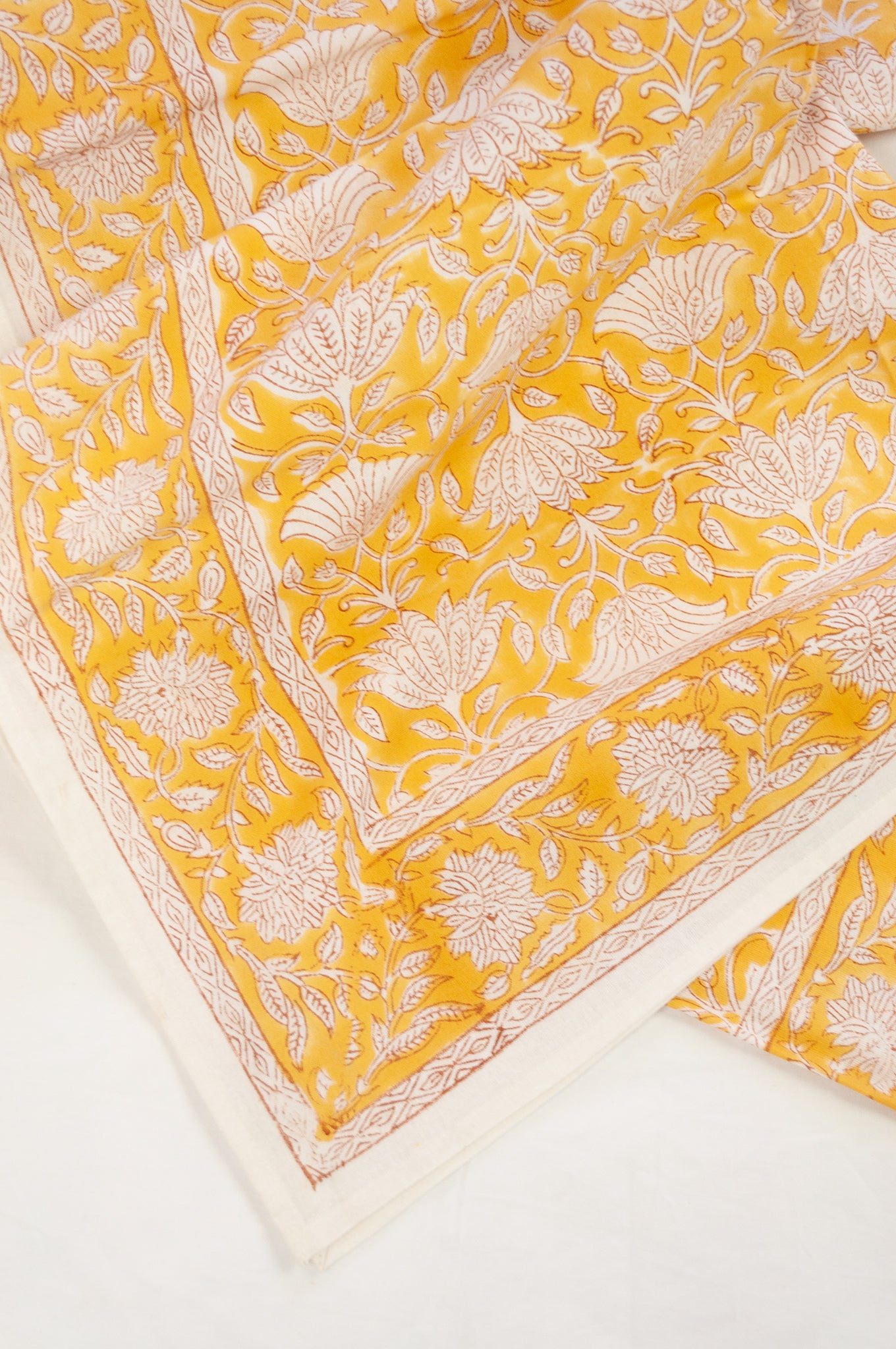 Cotton tablecloth, blockprinted by hand exclusively for Juniper Hearth, Sara floral in white on honey yellow.