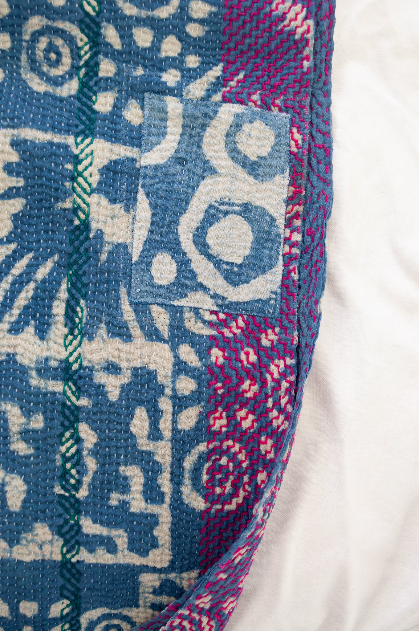 Vintage kantha quilt upcycled from cottonn saris, handstitched and overdyed with mud resist in natural indigo, and brilliant pink border stitching.
