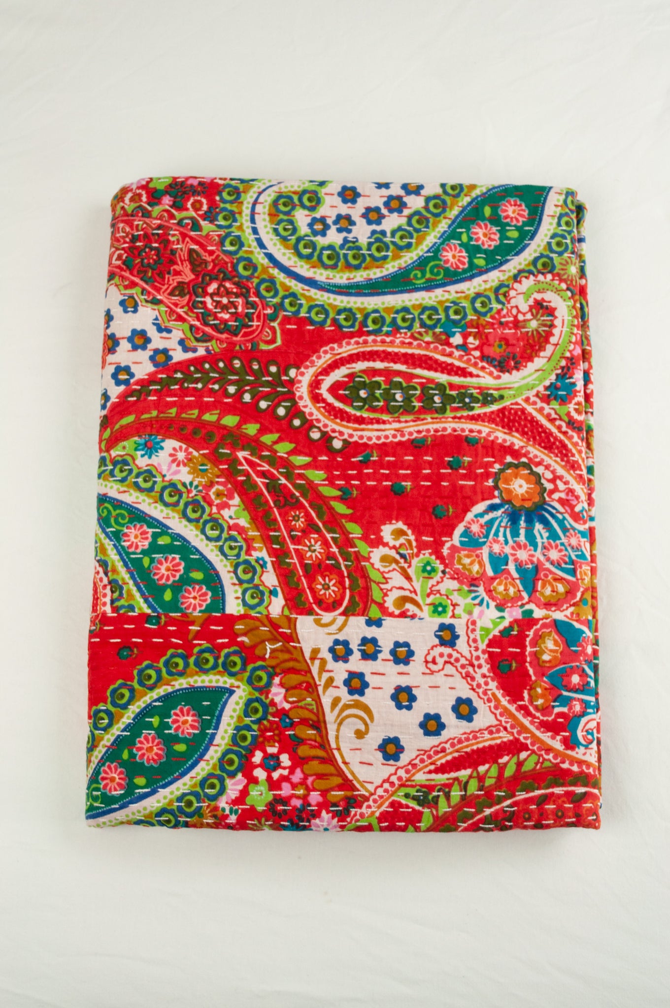 Handstitched cotton kantha quilt, a colourful paisley on a brilliant red background, with highlights in lime, emerald, turquoise, white, and tan