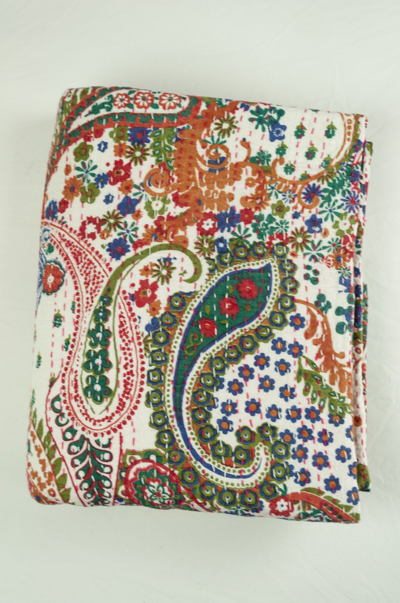 Handstitched cotton Kantha quilt paisley on a white background, with highlights in olive green, emerald, red, navy blue and tan