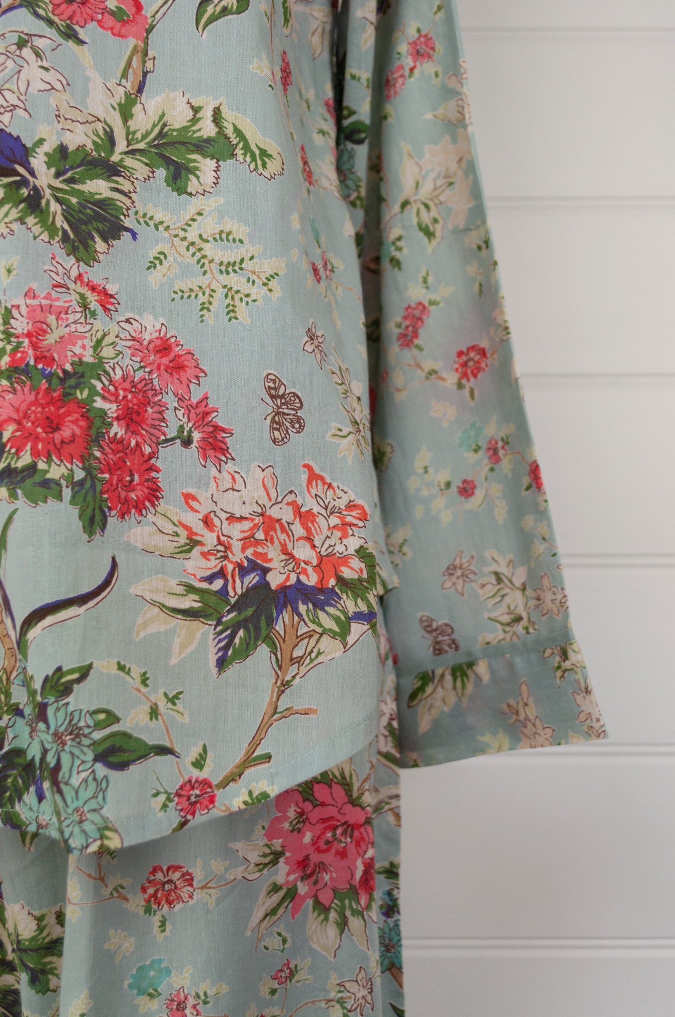 Juniper Hearth cotton voile pyjamas in Country Garden, floral print in rose pink, sage and aqua on soft blue green background.