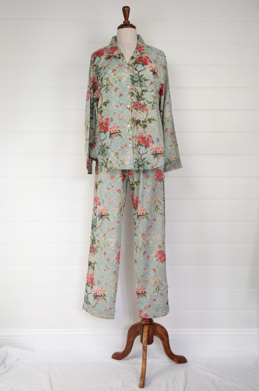 Juniper Hearth cotton voile pyjamas in Country Garden, floral print in rose pink, sage and aqua on soft blue green background.