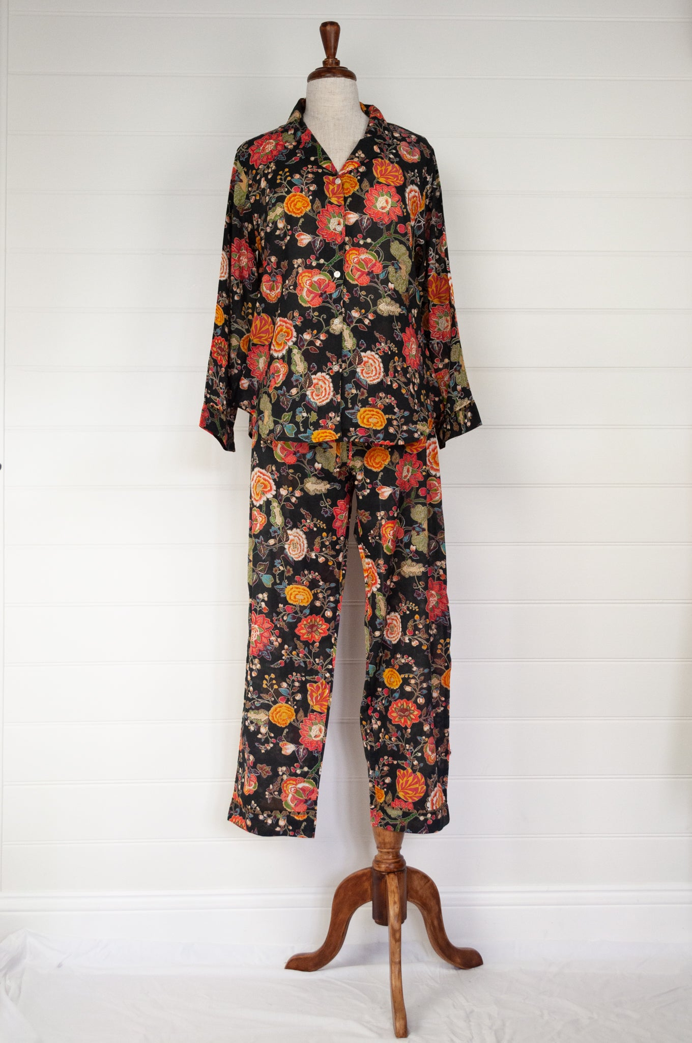 Ethically made cotton voile pyjamas, tropical print of red, gold and orange flowers on black background.
