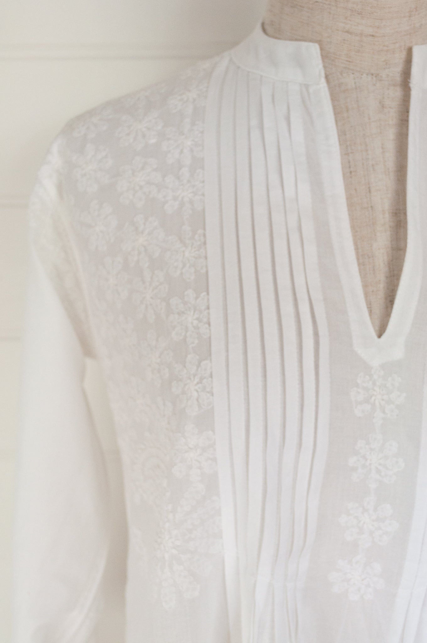 White on white chikankari embroidered pintucked blouse.