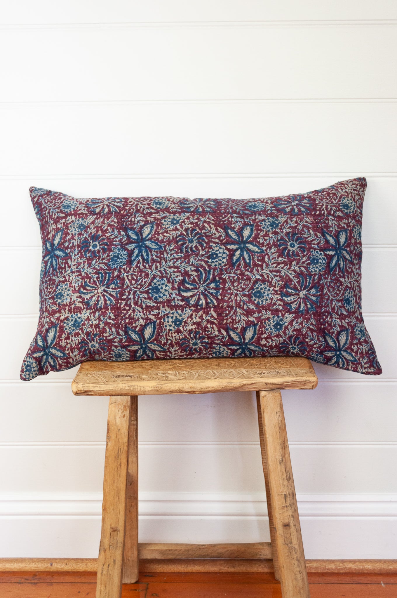Vintage kantha oblong rectangular bolster cushion blockprinted with floral design in indigo and deep burgundy red.