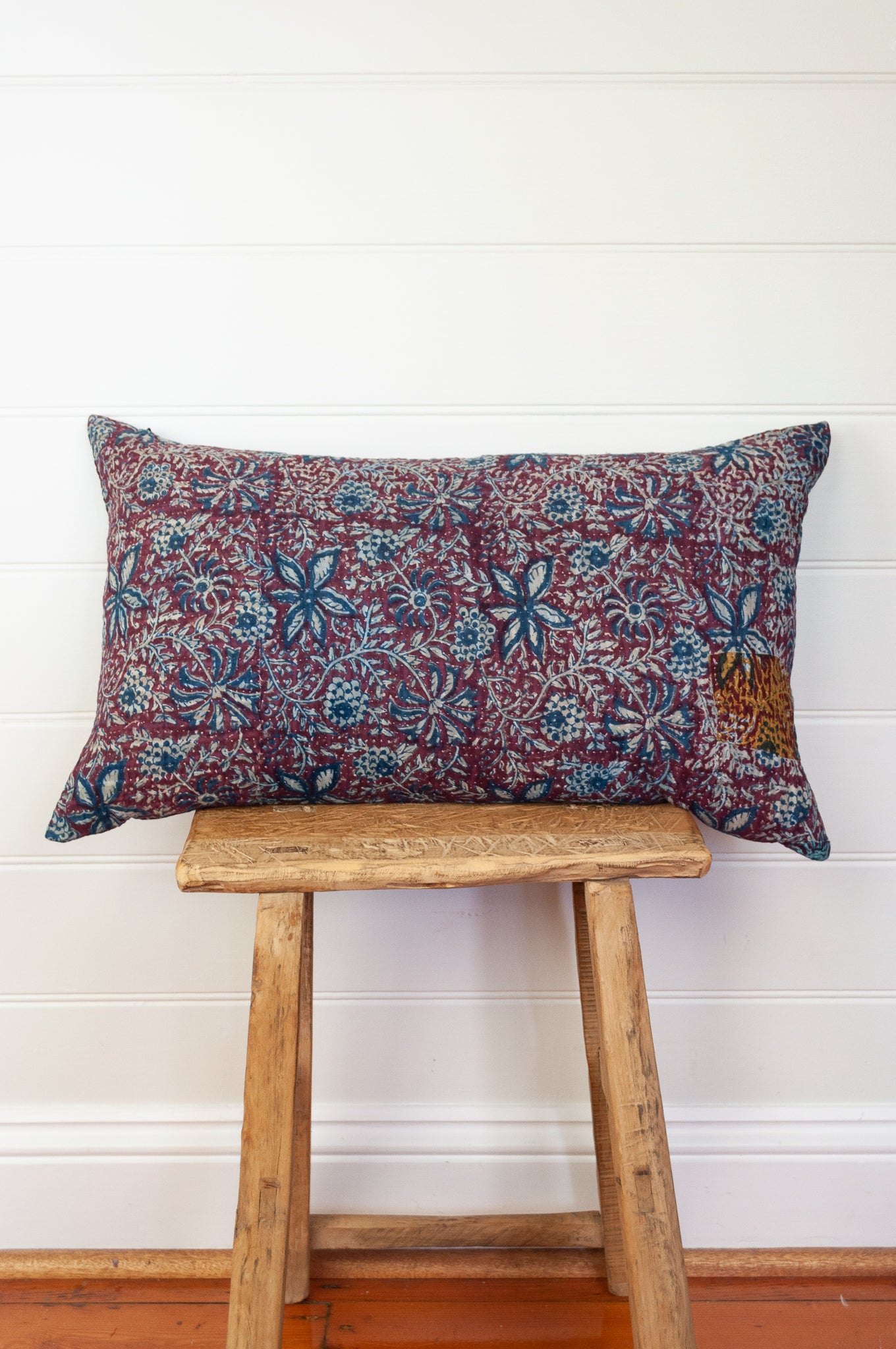 Vintage kantha oblong rectangular bolster cushion blockprinted with floral design in indigo and deep burgundy red.