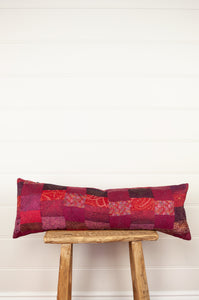 Vintage silk patchwork kantha bolster cushion 20x60cm is in shades of magenta, deep rose pink, and red.