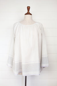 Juniper Hearth Yuka top in fine white cotton with self check, fine black stripe border with lavender highlight, gathered neck, loose fit one size long sleeve smock tunic top.