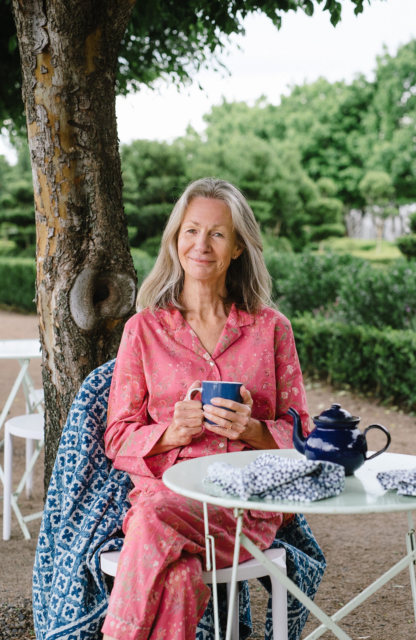 Ethically made cotton voile pyjamas with garden flowers of pink, red and vanilla on a deep raspberry pink red background.