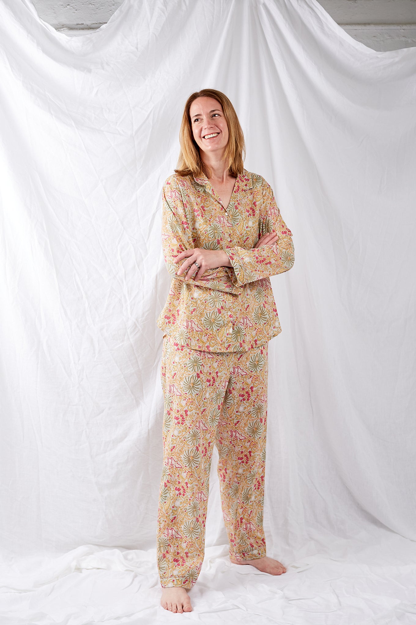 Ethically made cotton voile pyjamas featuring a print of palm trees, vines and butterflies in sage green, lemon and raspberry pink on a soft lime green background.
