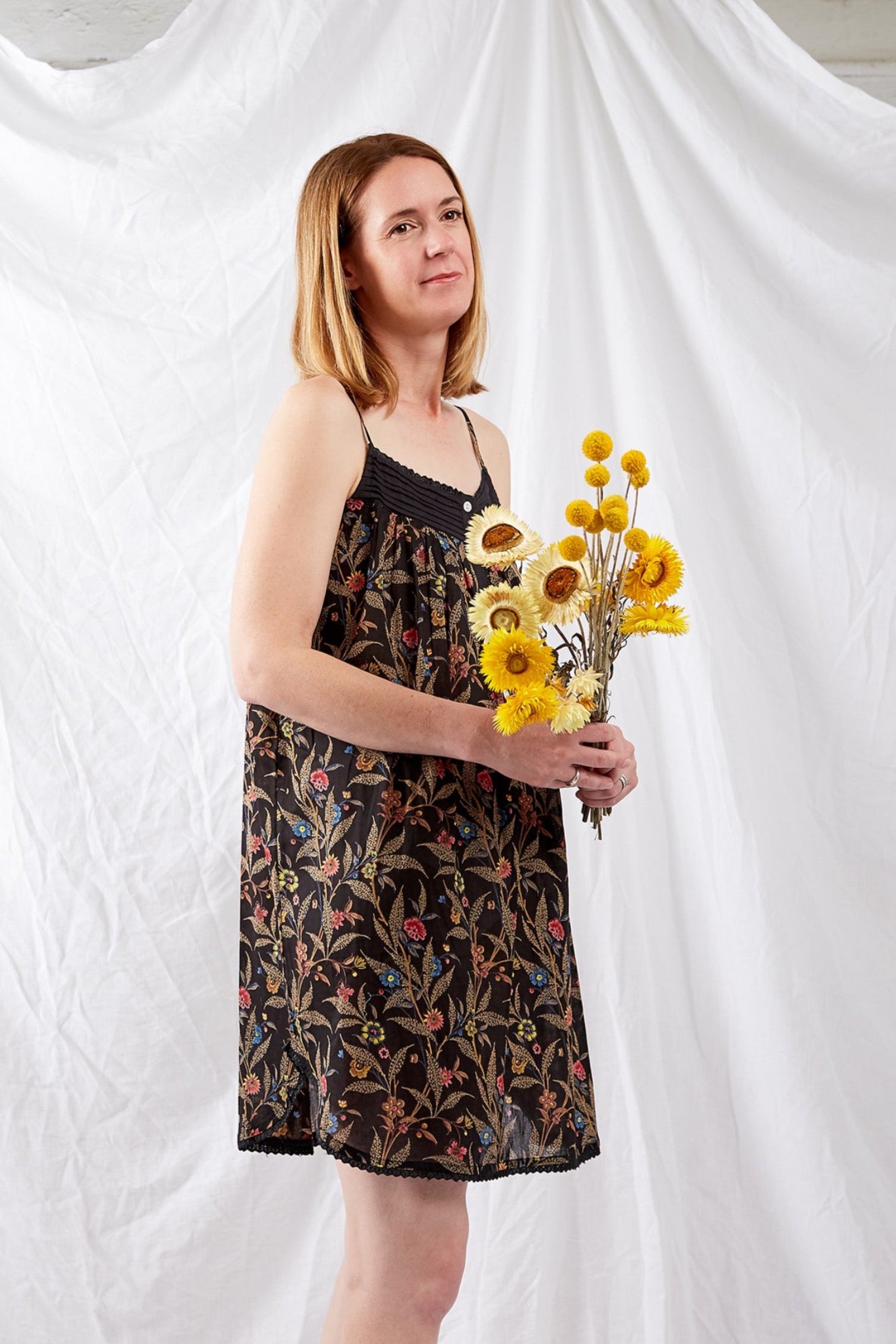 Ethically made pure cotton voile summer nightdress with adjustable straps and pintucked yoke, this nightie is in a wildflower print on black with broderie edging.
