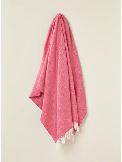Bronte by Moon Herringbone throw in cerise pink merino wool. Made in England.