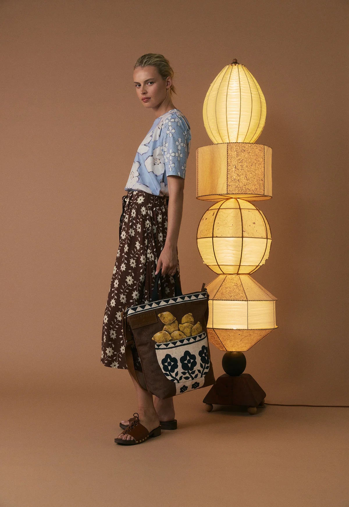 Nancybird brown shoulder bag featuring a front pocket printed with yellow lemons and a white floral pattern, set against a clean white background.