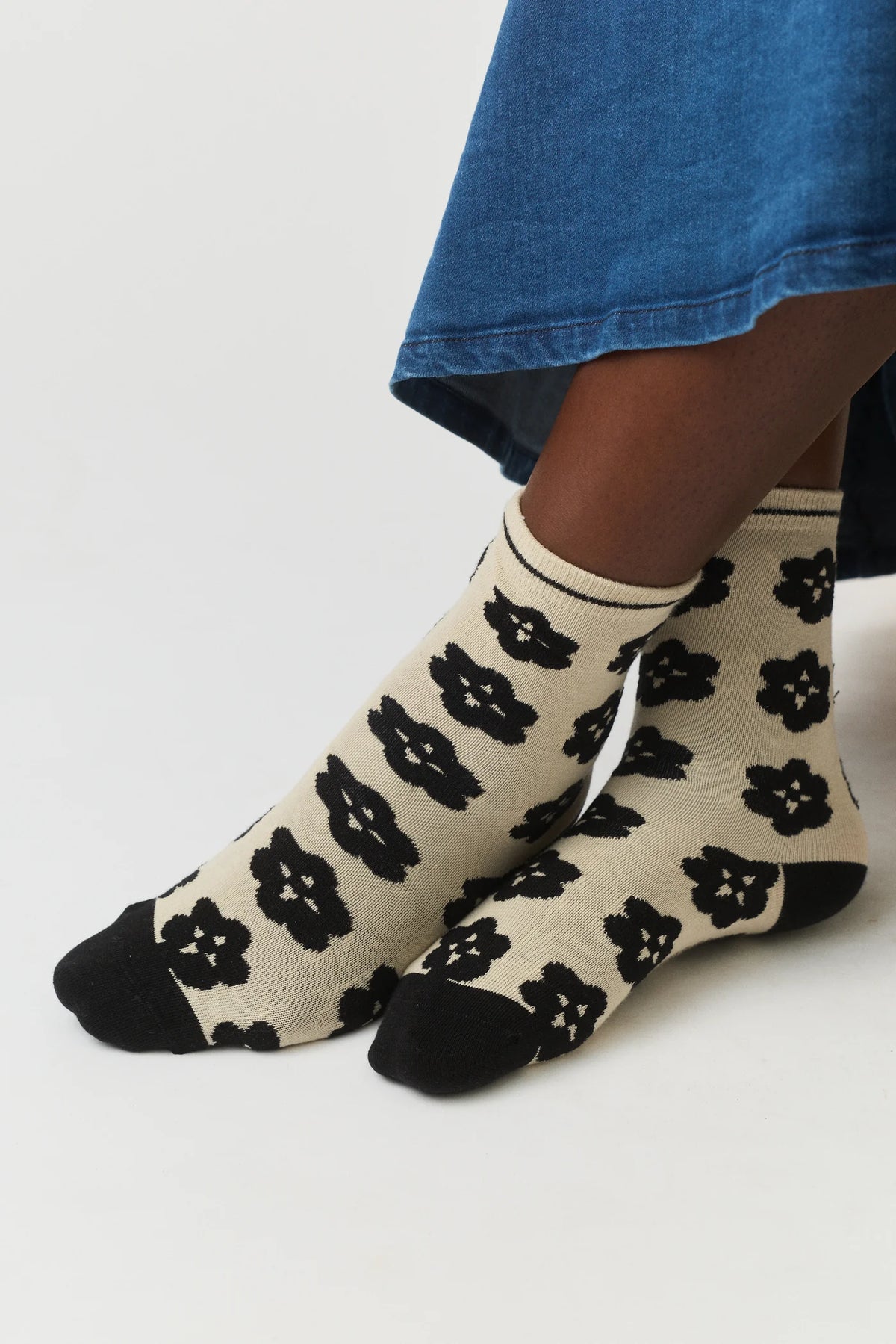 Nancybird Orakawa beige sock with black floral pattern on a white background.