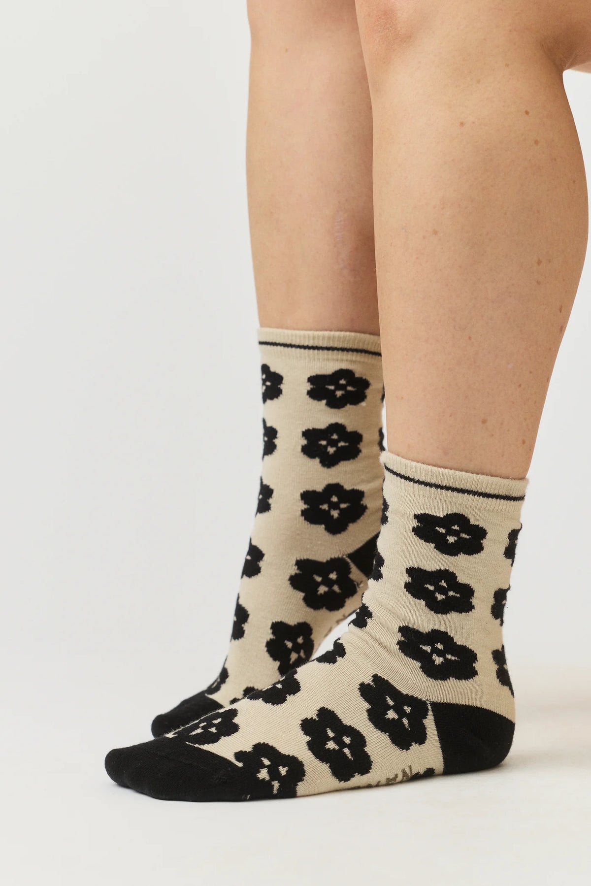 Nancybird Orakawa beige sock with black floral pattern on a white background.