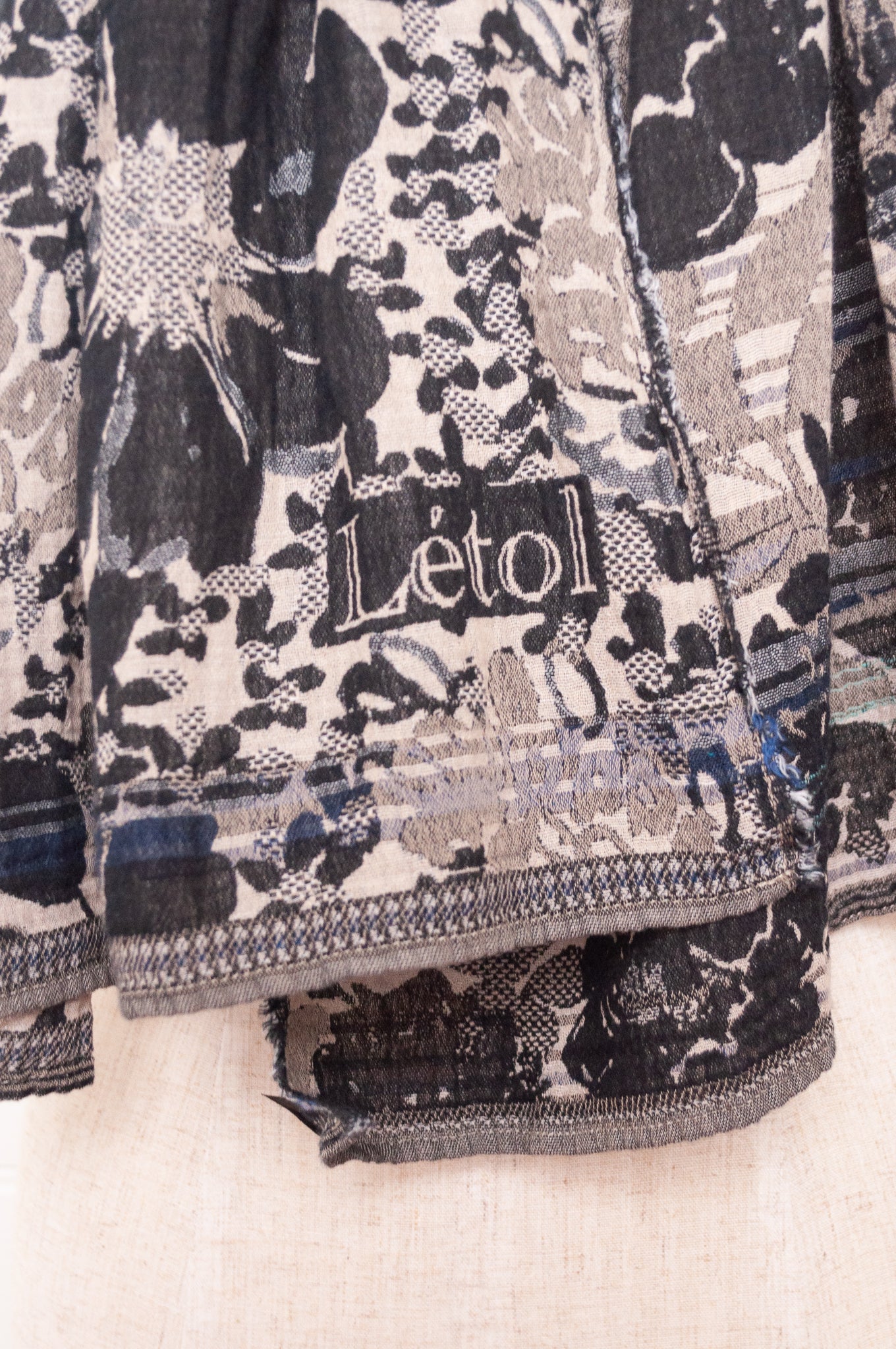 Letol organic cotton floral jacquard scarf Emilienne floral design in black, with highlights of blue.