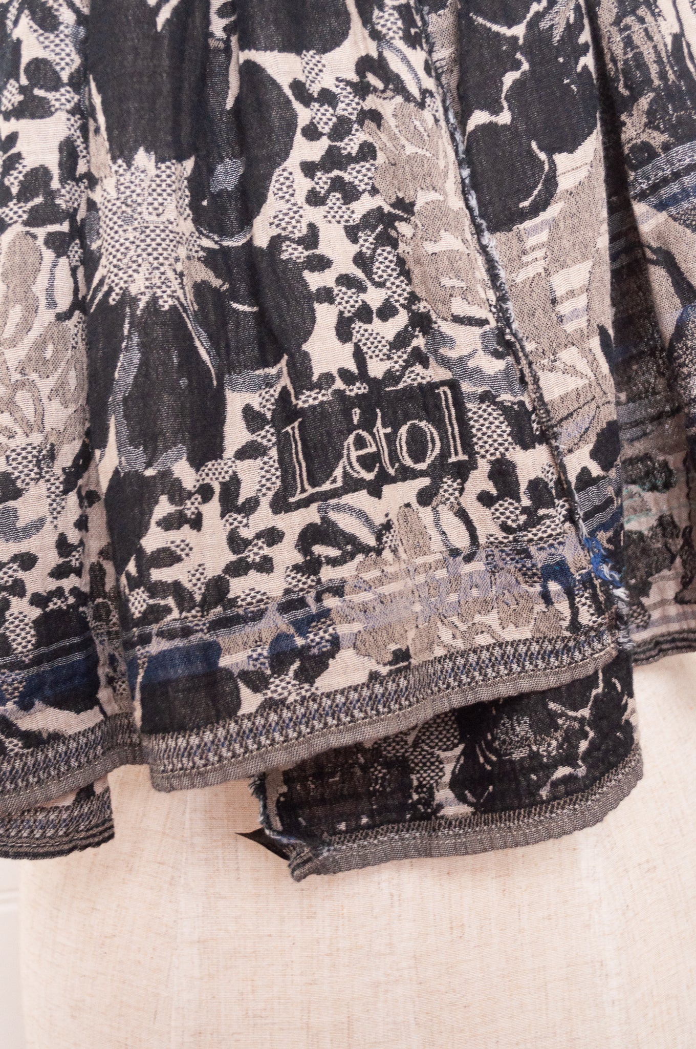 Letol organic cotton floral jacquard scarf Emilienne floral design in black, with highlights of blue.