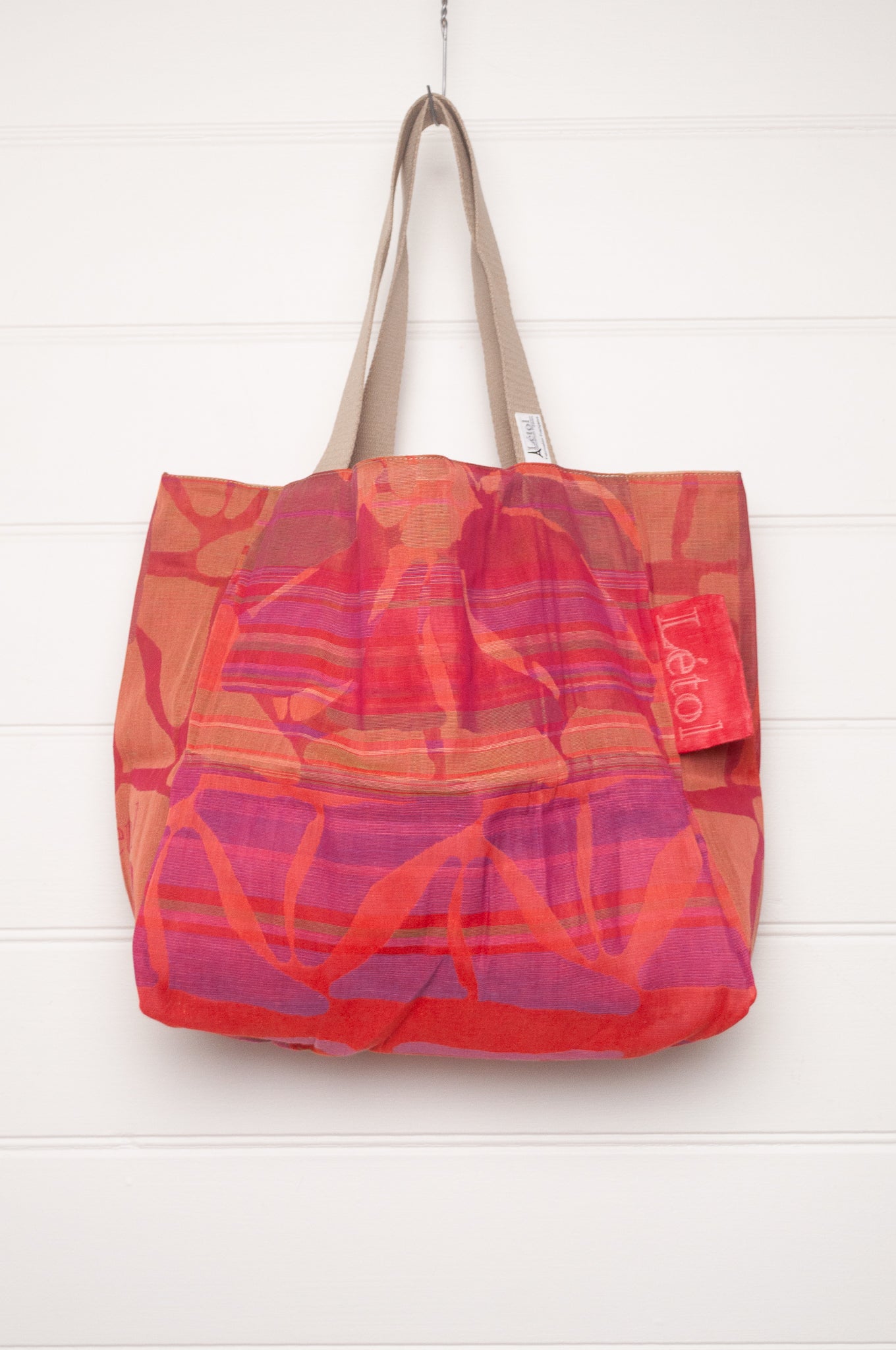 Letol organic cotton jacquard weave tote bag in stripes in pink, orange and red, and floral design.