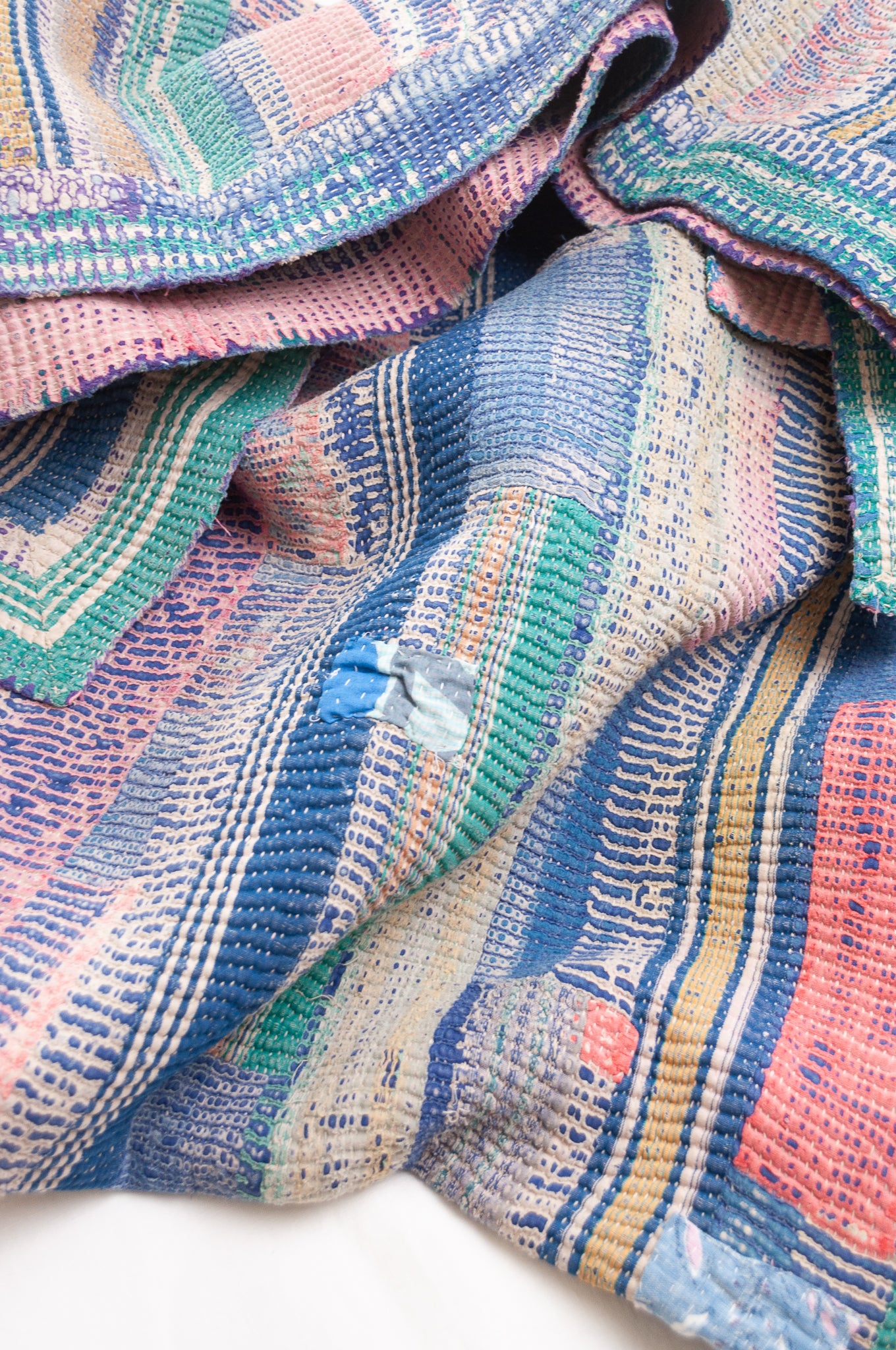 Vintage kantha quilt in deep pink, bluel lavender and green stripes.