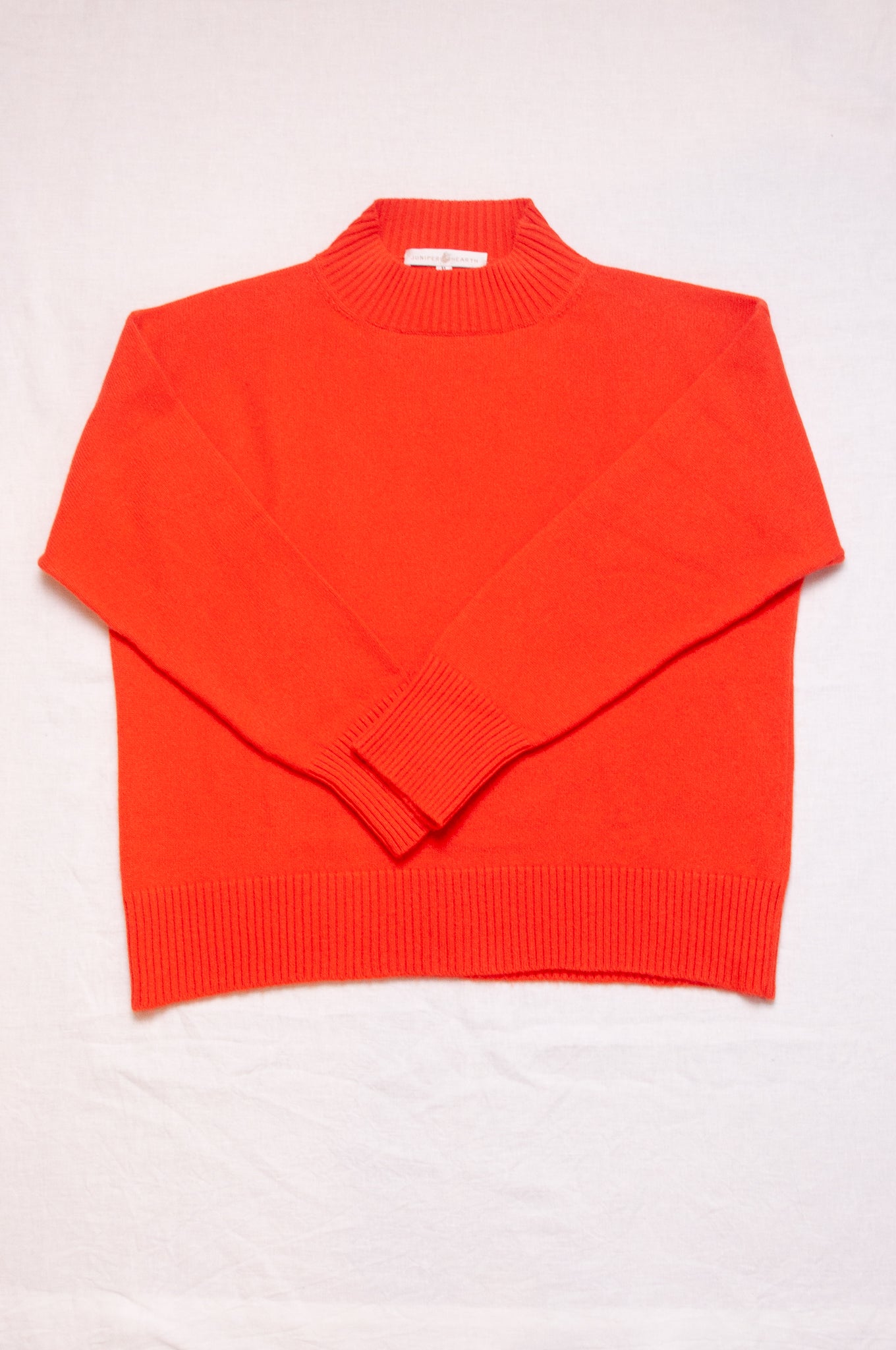 Cashmere turtle neck sweater in tangerine red orange.