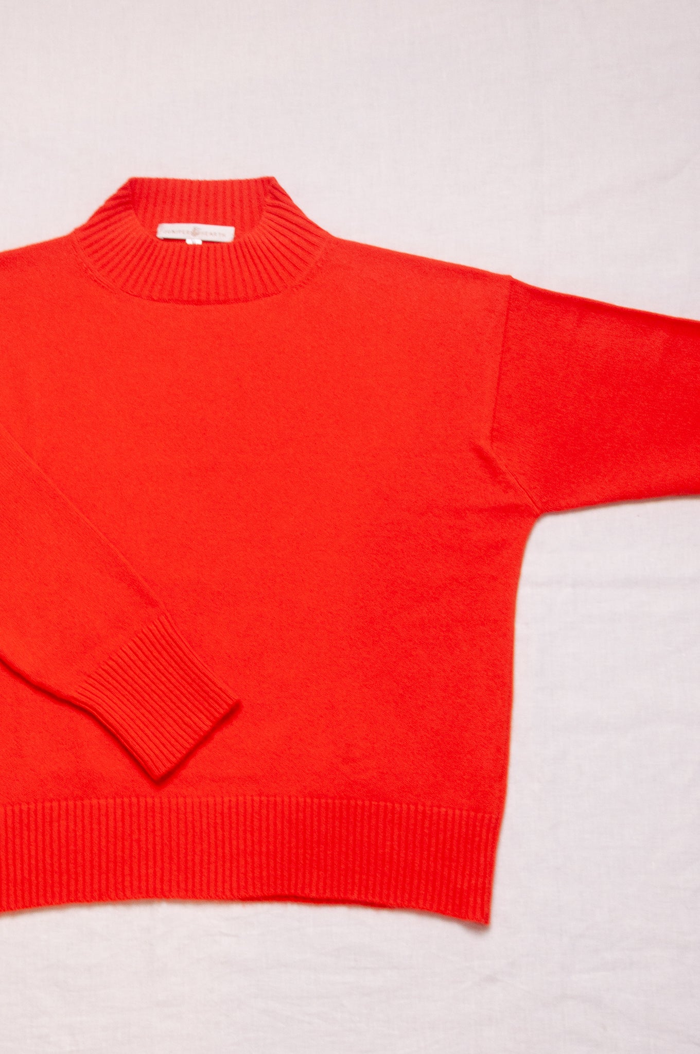 Cashmere turtle neck sweater in tangerine red orange.