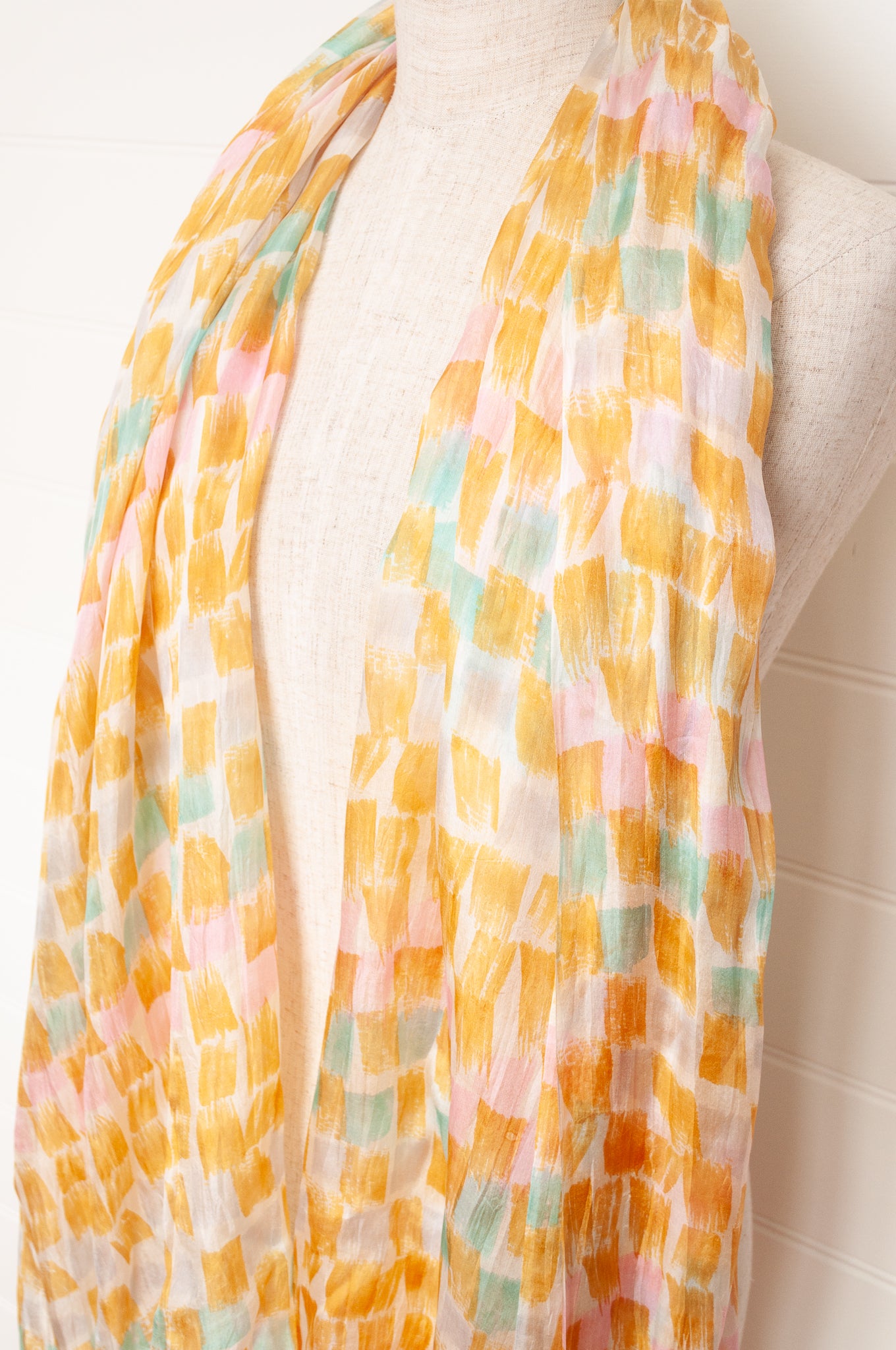 Hand painted pure silk scarf with light mustard pink and aqua blue brushstrokes on white.