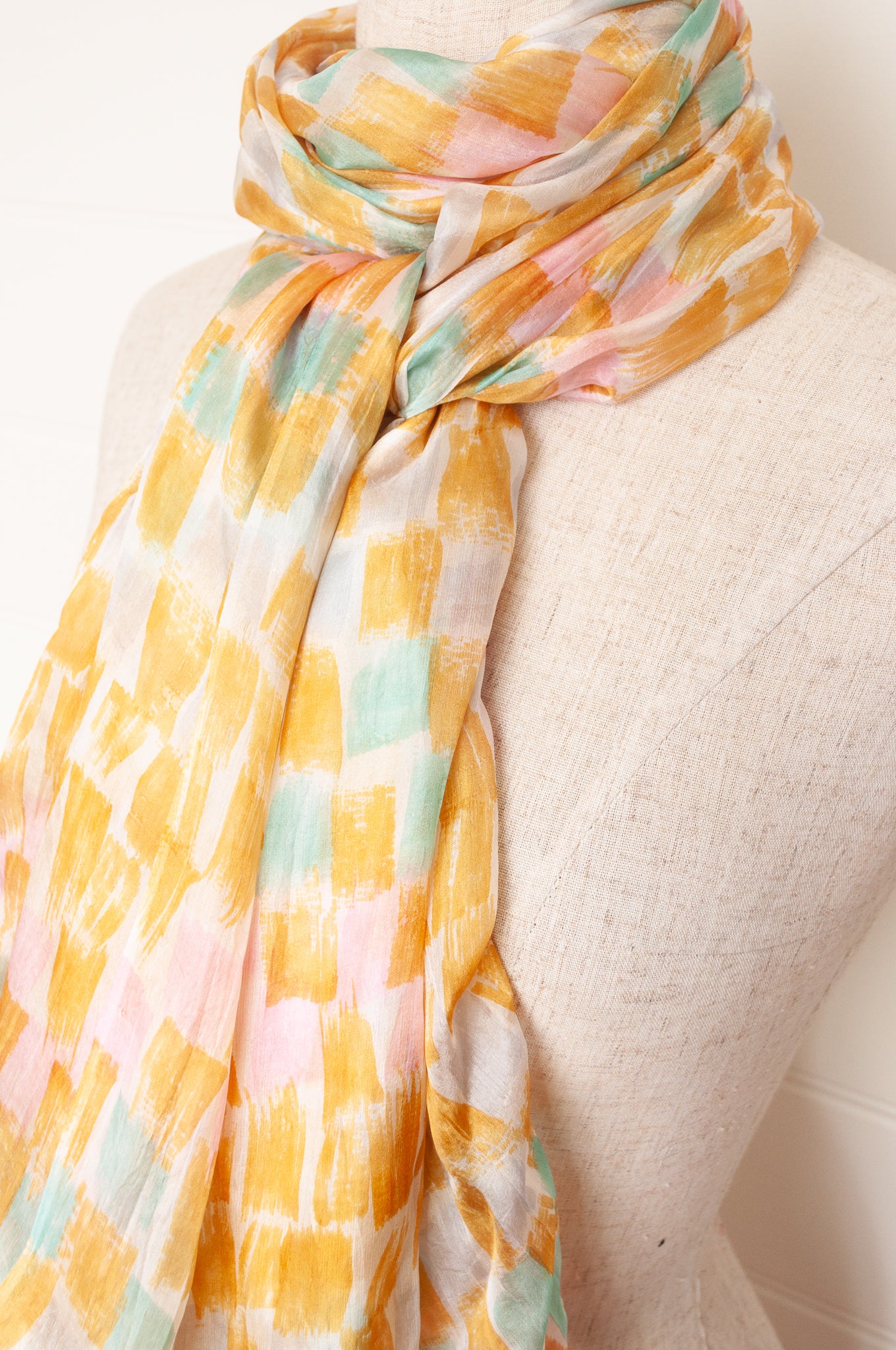 Hand painted pure silk scarf with light mustard pink and aqua blue brushstrokes on white.