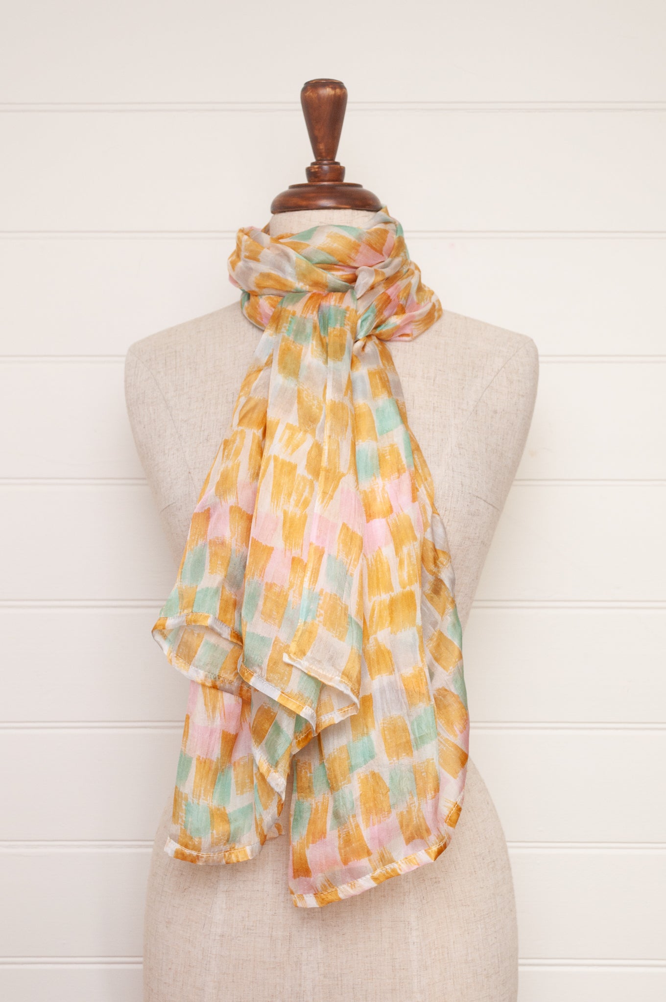 Hand painted pure silk scarf with light mustard pink and aqua blue brushstrokes on white.