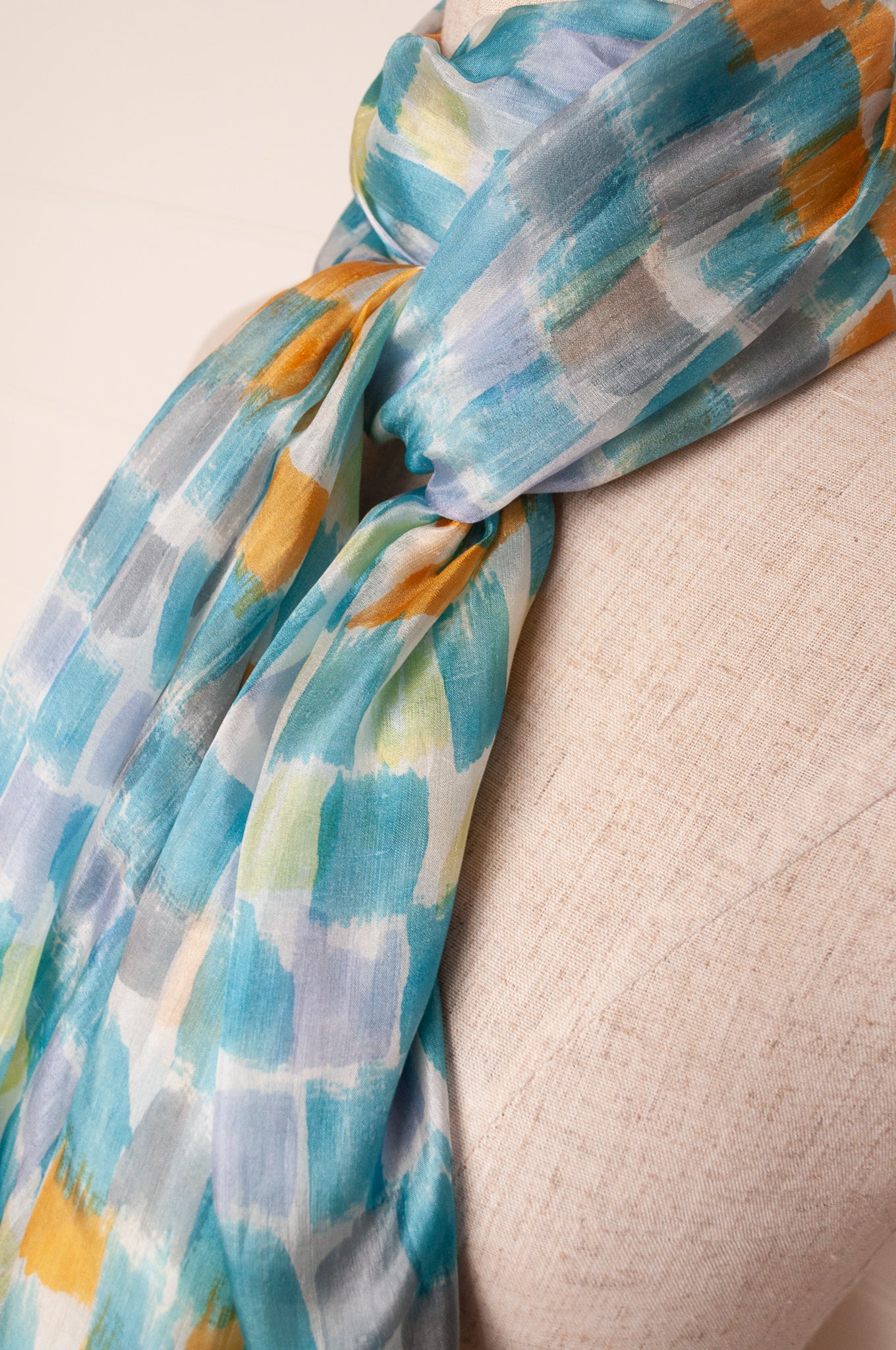 Hand painted pure silk scarf with aqua and gold brushstrokes on white.