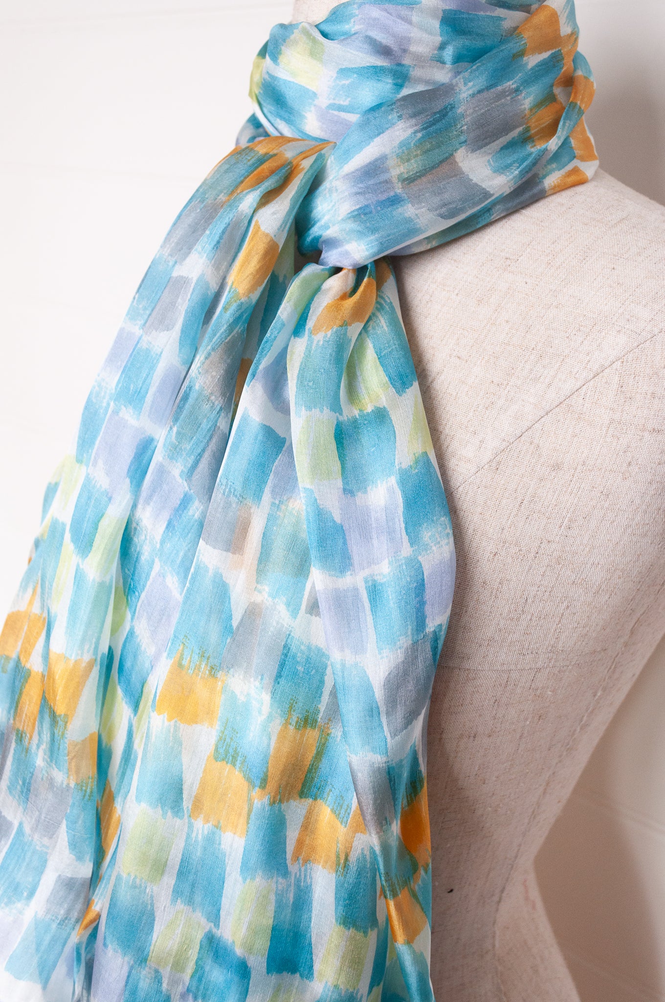 Hand painted pure silk scarf with aqua and gold brushstrokes on white.