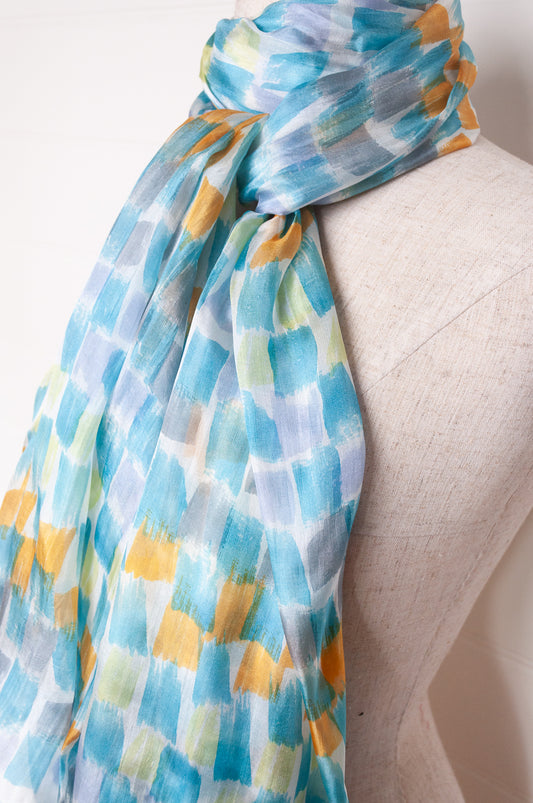 Hand painted pure silk scarf with aqua and gold brushstrokes on white.