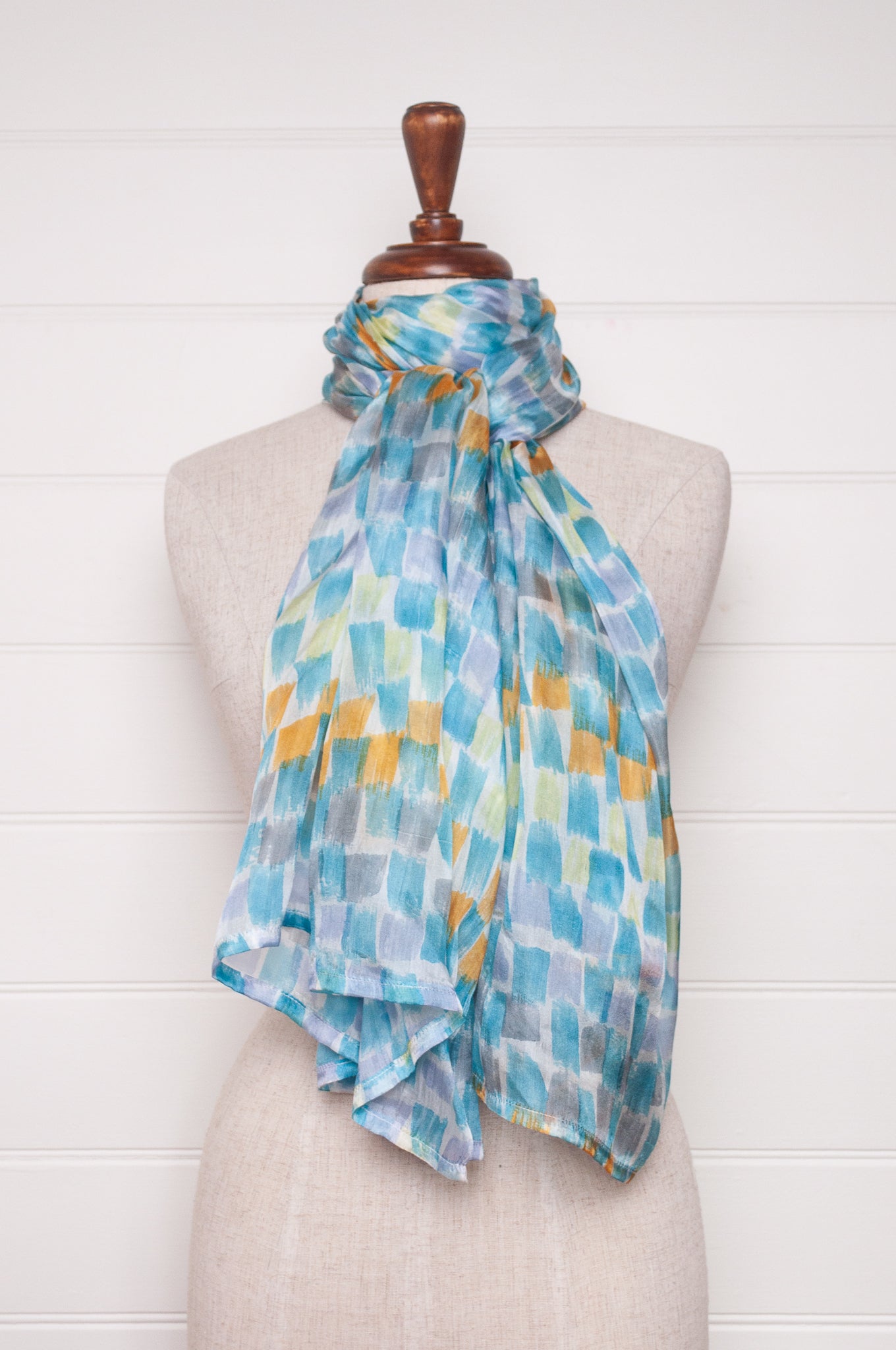 Hand painted pure silk scarf with aqua and gold brushstrokes on white.