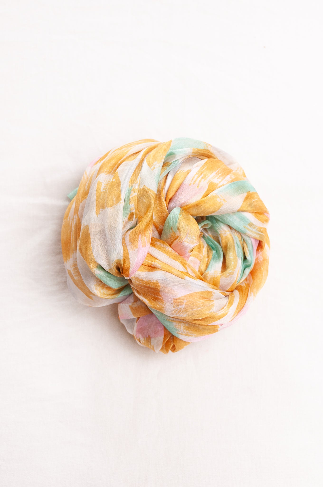 Hand painted pure silk scarf with light mustard pink and aqua blue brushstrokes on white.