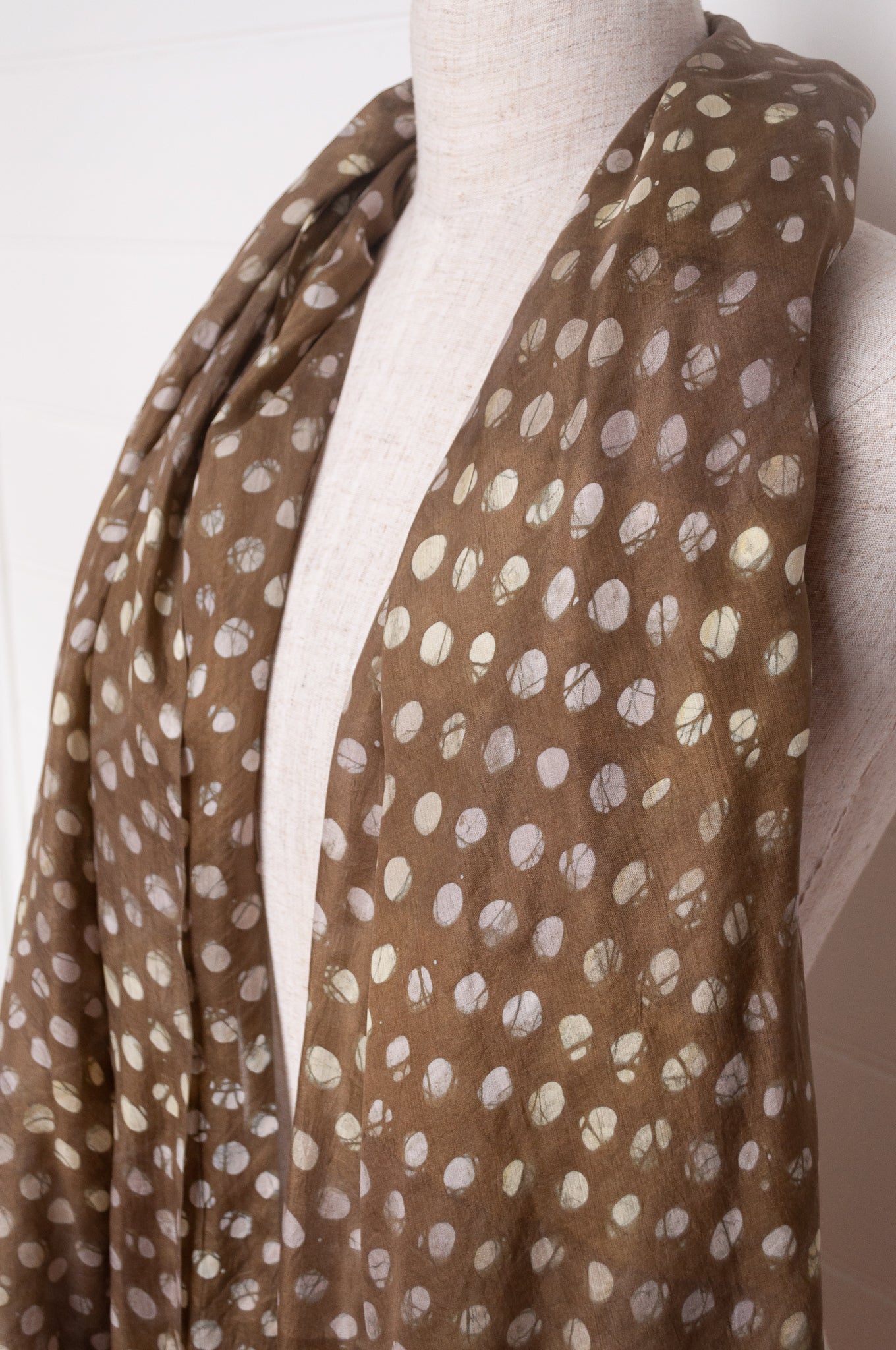 Pure silk shibori dyed  scarf in deep olive green with white spots.