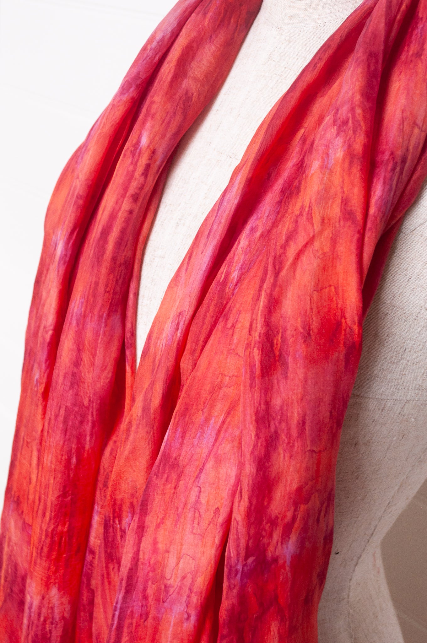 Pure silk shibori dyed scarf in shades of rose pink and red.