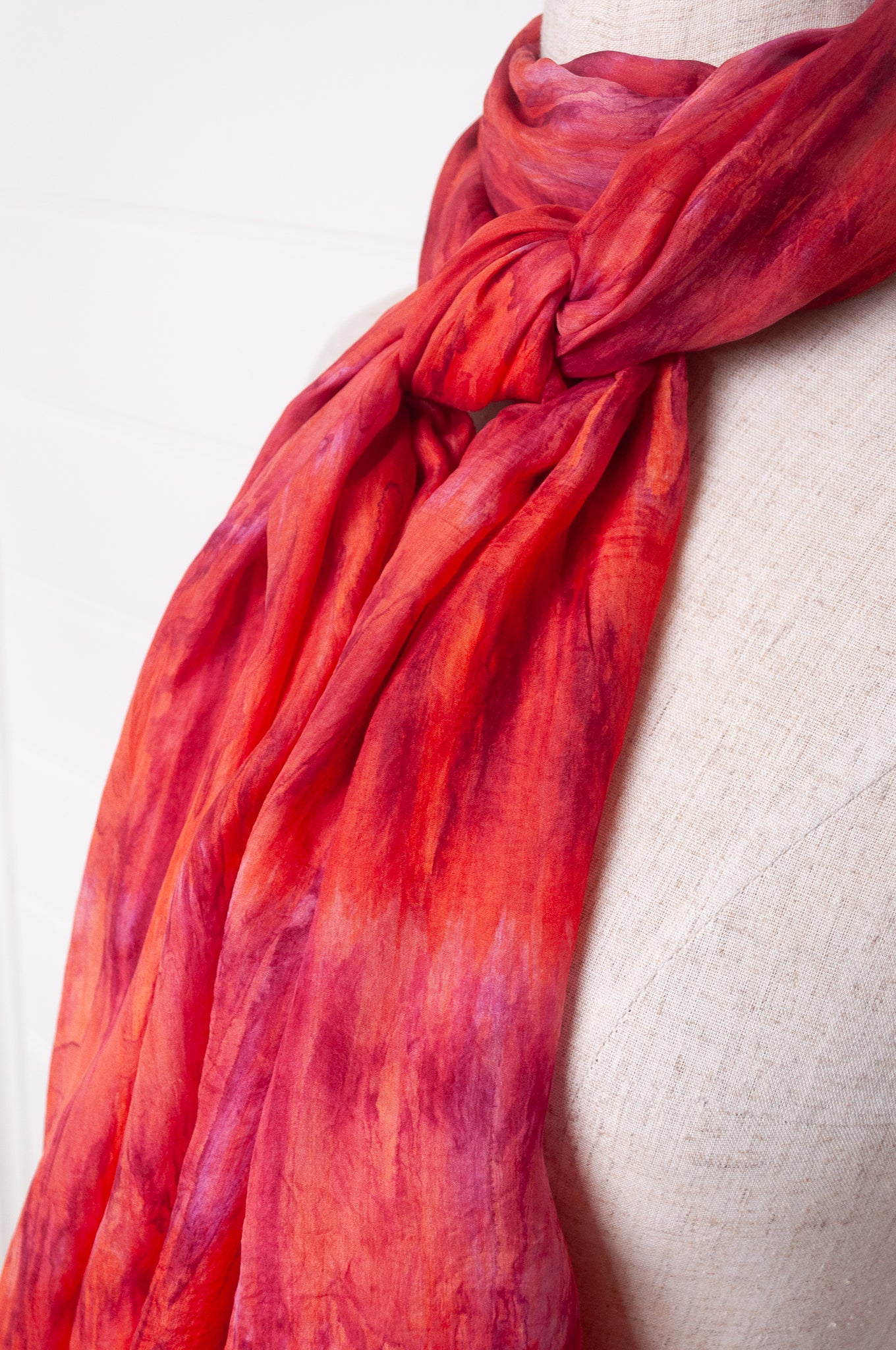 Pure silk shibori dyed scarf in shades of rose pink and red.