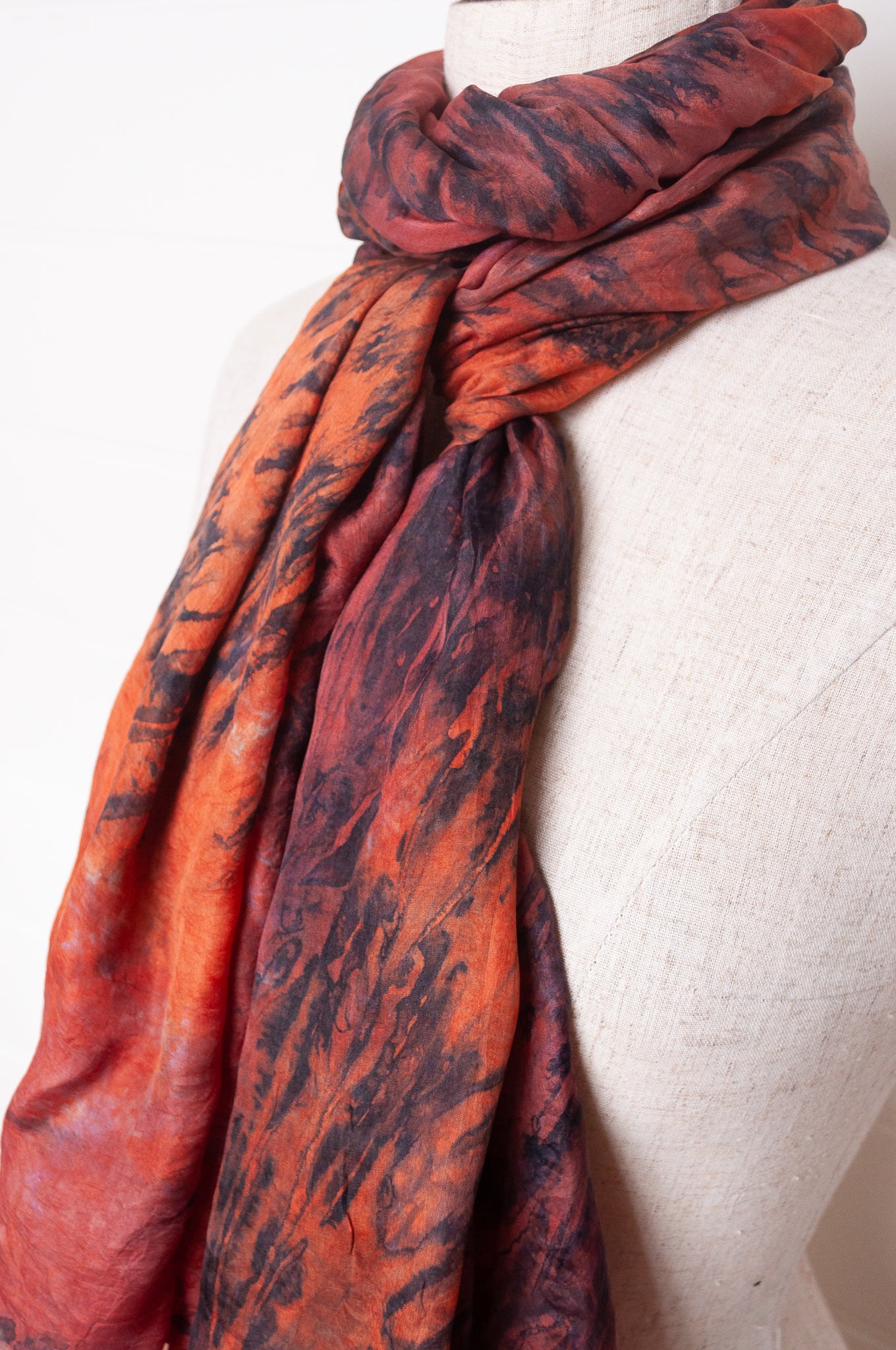 Pure silk shibori dyed scarf in shades of deep red, orange and brown.